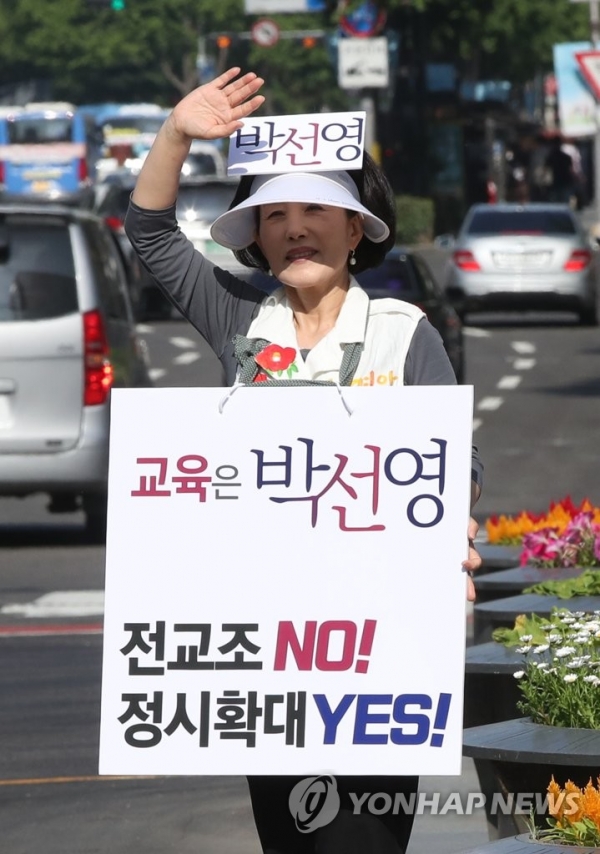 6.13 지방선거 공식 선거운동이 시작된 31일 오전 서울 광화문광장에서 박선영 서울시교육감 후보가 "전교조 NO, 정시확대 YES"라고 쓴 피켓을 목에 걸고서 출근길에 오른 시민들을 향해 지지를 호소하고 있다