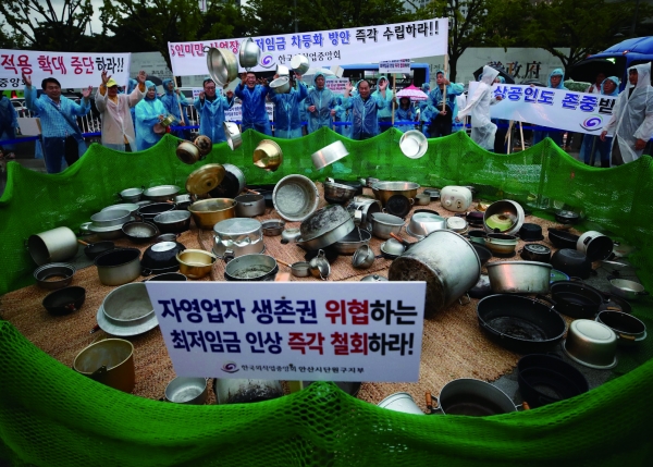 8월 29일 서울 광화문 광장에서 열린 전국 소상공인 최저임금 제도개선 촉구 국민대회에서 참가들이 솥을 던지는 퍼포먼스를 하고 있다 / 연합